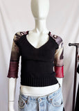 Mannequin wearing a black mesh y2k vintage top with colorful sleeves and light blue jeans against a white background